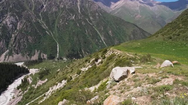 Drone footage captures the lush green mountains of Ala Archa National Park, Kyrgyzstan, showcasing its natural beauty and serene landscape.