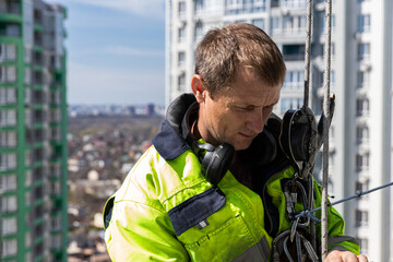 Dedicated Worker on High-Rise Building Preparing for Task with Focus and Precision in a Busy Urban...
