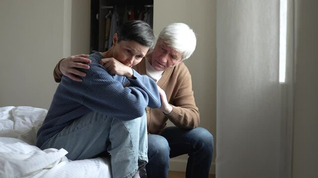Tearful distraught wife weeping, husband hugging offering comfort. Miscarriage sorrow, family crisis, unbearable grief, mental health issues, depression battle, emotional exhaustion, couple coping