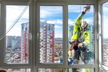 Window Cleaner Operations on a High-Rise Building with a Breathtaking Cityscape View Completely...