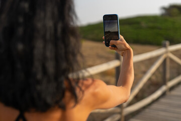 Brunette Woman Taking a Photo with Her Smartphone at the Beach
