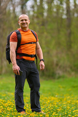 Fototapeta premium Happy man hiking in spring meadow