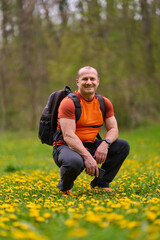 Man squatting in spring meadow