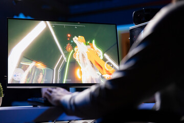 Man playing SF FPS videogame, having fun in dark apartment room, using gaming computer peripherals....