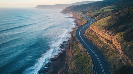 Fototapeta premium A winding coastal road beside the ocean waters on the horizon