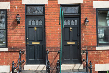 Doorway with two doors with porch in a red brick house.