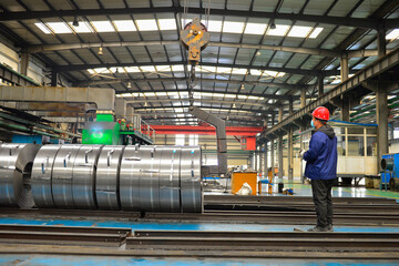 Workers on the production line of the strip steel coil factory are working
