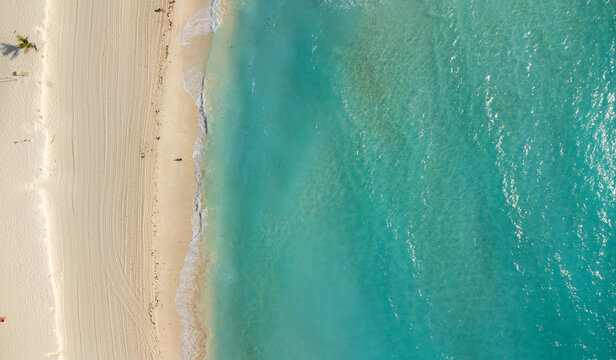 aerial view of white sand beach with turquoise water