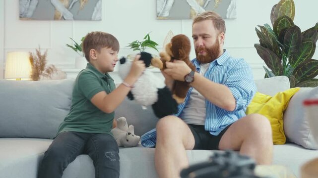 A man and boy share joyful playtime with stuffed animals