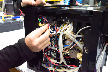 Professional repair and cleaning technician for coffee machine parts with a sprocket grinder for...