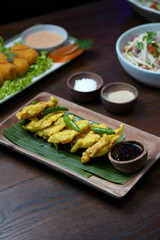 Golden Fried Tempeh Mendoan with Green Chili and Dipping Sauce on Banana Leaf