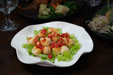Crispy Fried Tofu Bites with Sweet Chili Sauce on a Bed of Lettuce