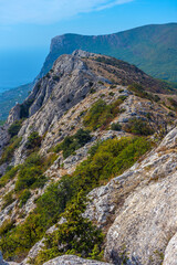 Mountain range in Crimea with picturesque cliffs covered with bushes and low-growing trees. 