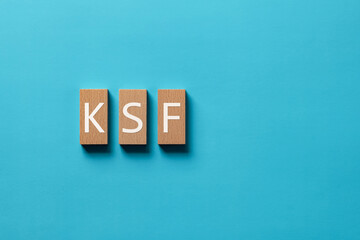 There is wood block with the word KSF. It is an abbreviation for Key Success Factor as eye-catching...