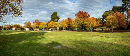 Panoramic view of a spacious suburban park in Werribee, Melbourne,with open green lawns, mature...