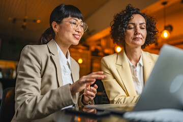two multicultural businesswoman entrepreneur use laptop for work