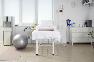 Interior of hospital ward with bed, drawers and cooler