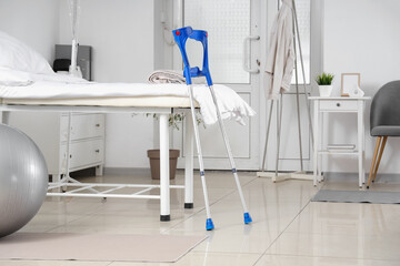 Interior of hospital ward with bed and crutches