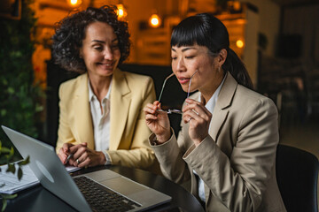 two multicultural businesswoman entrepreneur use laptop for work