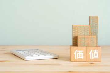 価値と書かれたブロック、電卓、不動産の模型
