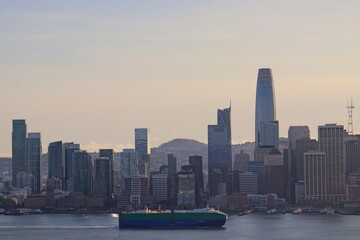 Fototapeta premium The sun sinks lower in the sky, casting shadows on the skyline of San Francisco