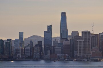 Obraz premium The sun sinks lower in the sky, casting shadows on the skyline of San Francisco