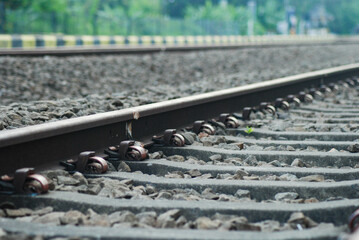 Railroad track detail close up, Railroad Tracks Perspective. Long iron railroad tracks surrounded...