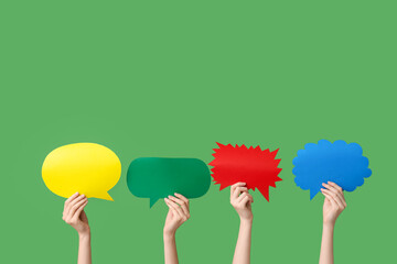 Female hands with colorful speech bubbles on green background