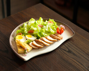Healthy Chicken Salad with Boiled Egg, Pineapple, and Fresh Vegetables on Ceramic Plate