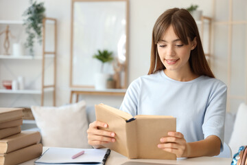 Obraz premium Happy female student reading books at home
