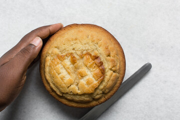 Overhead view of a round vanilla cake being cut into layers, process of making a layered cake