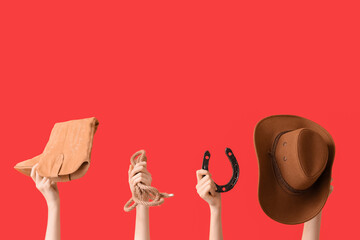 Female hands with cowboy hat, shoe, lasso and horseshoe on red background