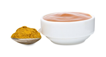 Tasty curry sauce in bowl and spoon with powder isolated on white