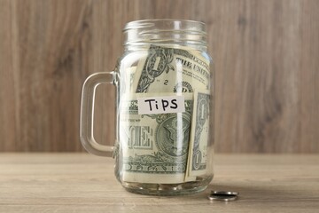 Mason jar with tips on wooden table, closeup
