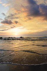 Obraz premium Peaceful Golden Sunset Over Gentle Waves at a Tropical Beach in Costa Rica