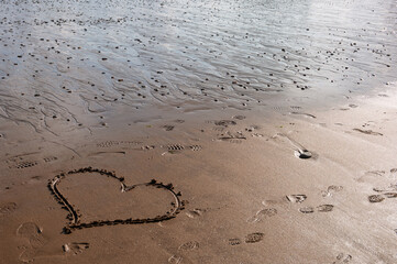 A heart is drawn in the sand on a beach