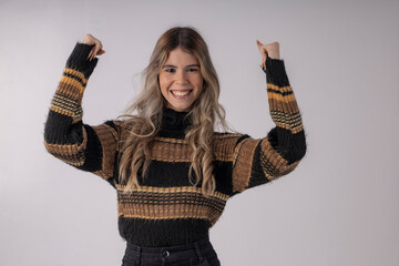 young woman wearing a blouse and skirt in studio photo with infinite background, making funny poses