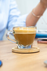 tasse de café au lait mousseux posé sur un bureau