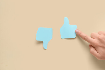 Man pointing at rating thumbs on beige background. Survey concept