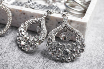 Beautiful silver earrings on grey background, closeup