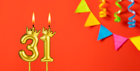 Number 31 candle - Birthday celebration on an orange background with pennants