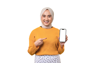 Beautiful smiling Asian girl wearing hijab pointing index finger at mobile phone with blank white screen isolated on transparent background, mockup, copy space