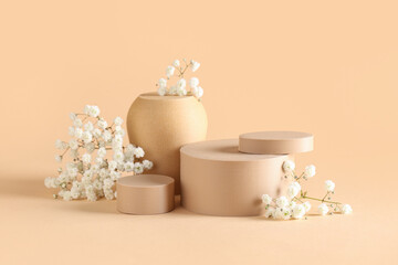 Beautiful gypsophila and plaster podiums on beige background