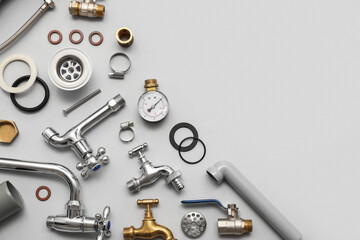 Set of plumber's items on grey background