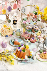 Easter table with traditional ring cakes, muffins and decors in pastel colors