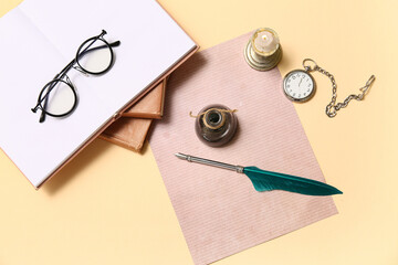 Old paper sheet with books, nib pen, inkwell, glasses and pocket watch on beige background