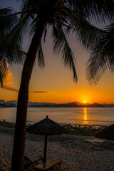 Daybeds and hotels in the morning light in Dadonghai beach in Sanya, Hainan, China