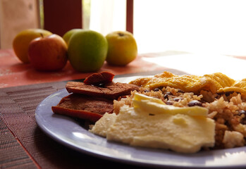 Traditional Costa Rican breakfast, rice and beans, called Gallo Pinto with eggs, tortilla, sausage and plantain.