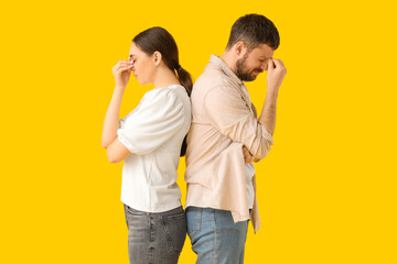 Offended young couple after quarrel on yellow background
