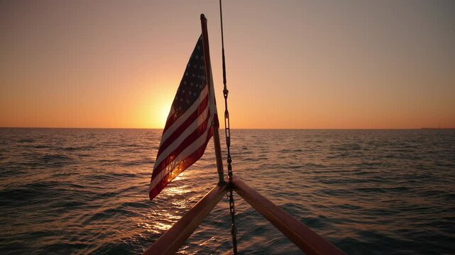 Experience the beauty of an American flag waving on a sailing ship at sunset, captured in slow motion against the stunning backdrop of Key West, Florida, creating a tranquil atmosphere